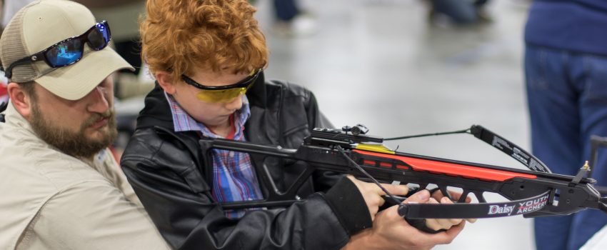 A youngster tries out a Daisy crossbow at the National Wild Turkey Convention.